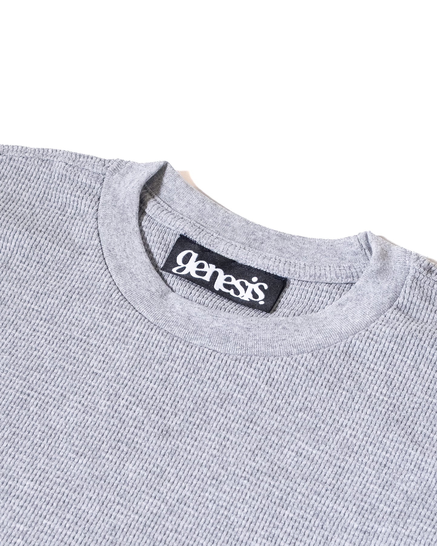 Gray sweater with 'genesis' brand label on a white background