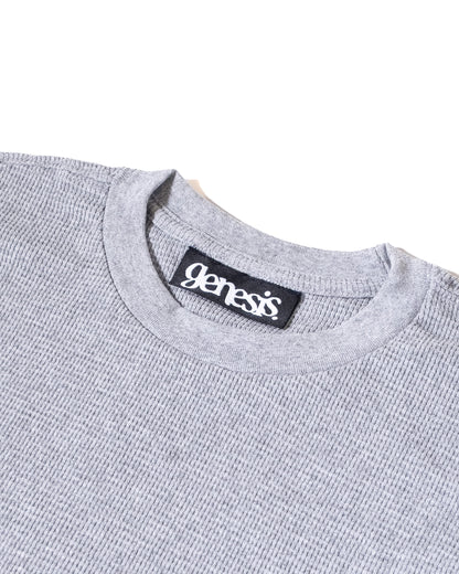 Gray sweater with 'genesis' brand label on a white background