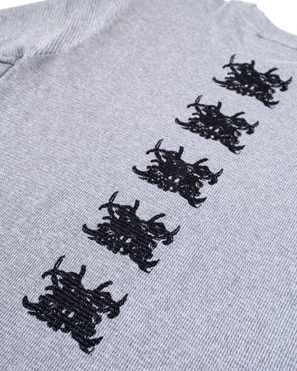 Gray sweater with black embroidered patterns on a white background