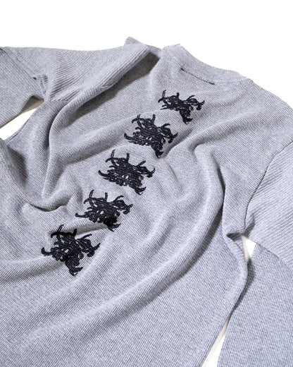 Gray sweater with black embroidered designs on a white background