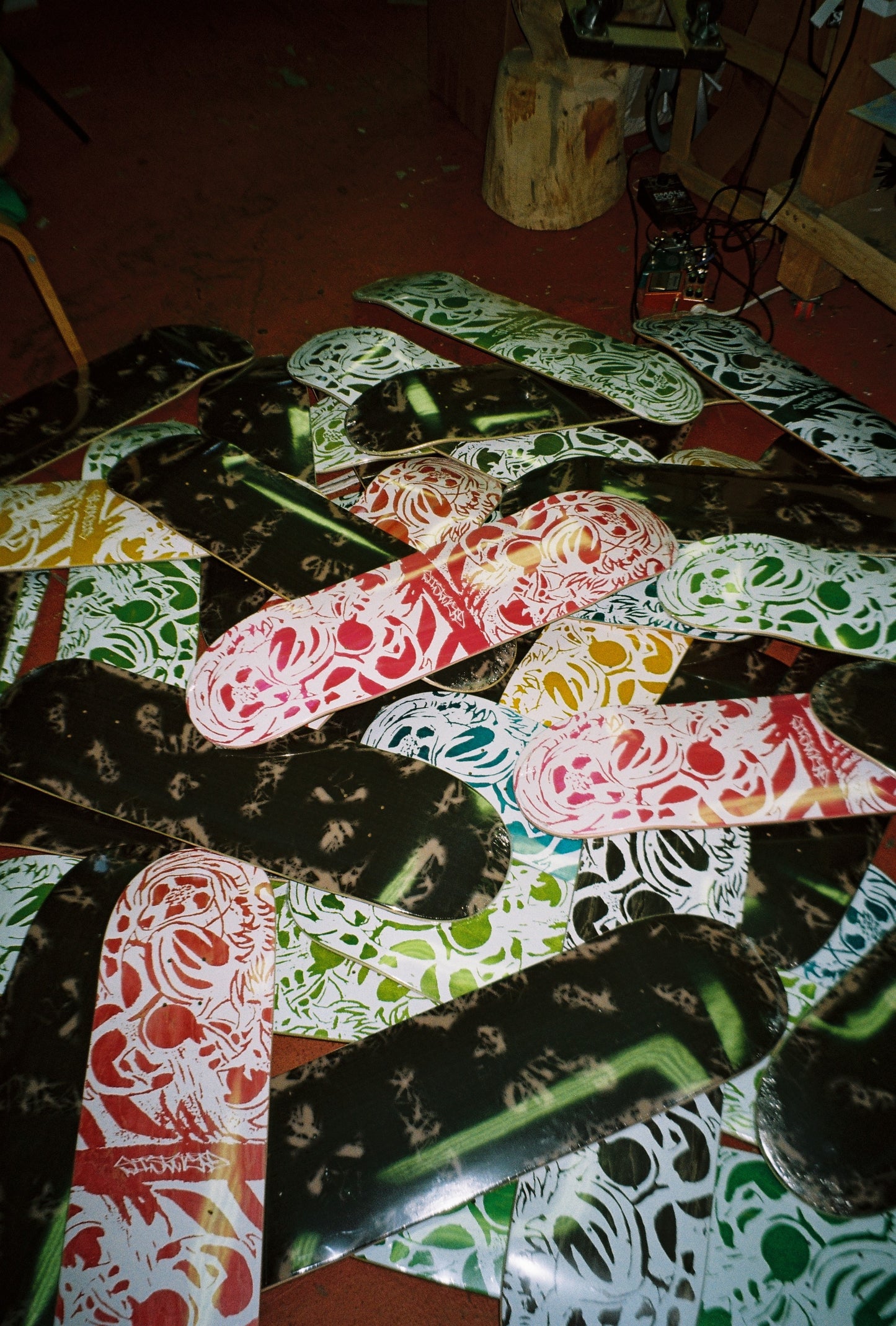 Collection of skateboard decks with various designs on a wooden floor.