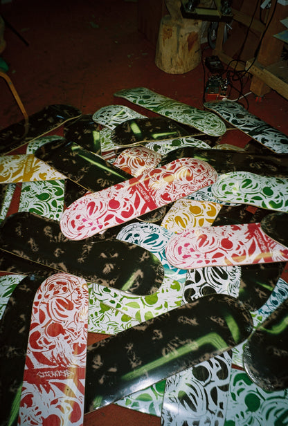 Collection of skateboard decks with various designs on a wooden floor.